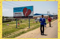 People pass by an AIDS Healthcare Foundation awareness billboard in Maputsoe, Lesotho, on January 31, 2020. People pass by an AIDS Healthcare Foundation awareness billboard in Maputsoe, Lesotho, on January 31, 2020.