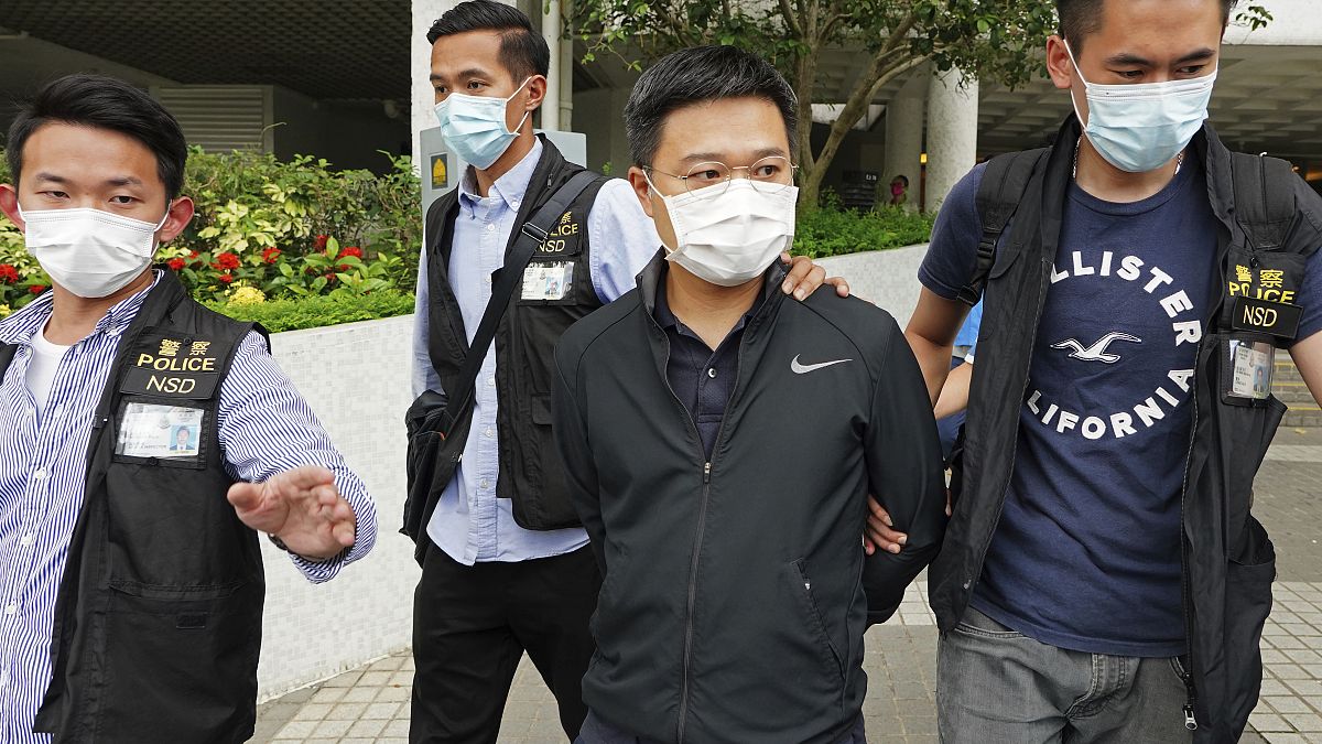 Ryan Law, second from right, Apple Daily's chief editor, is arrested by police officers in Hong Kong Thursday, June 17, 2021