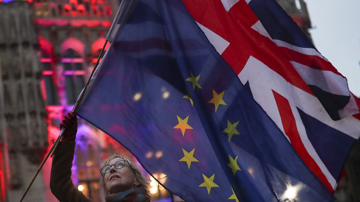 A woman holds up the British Union and the European Union flags together during an event in Brussels, Belgium on Jan. 30, 2020.