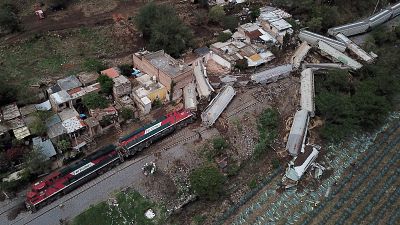A freight train derailed and toppled onto houses alongside the tracks in western Mexico.