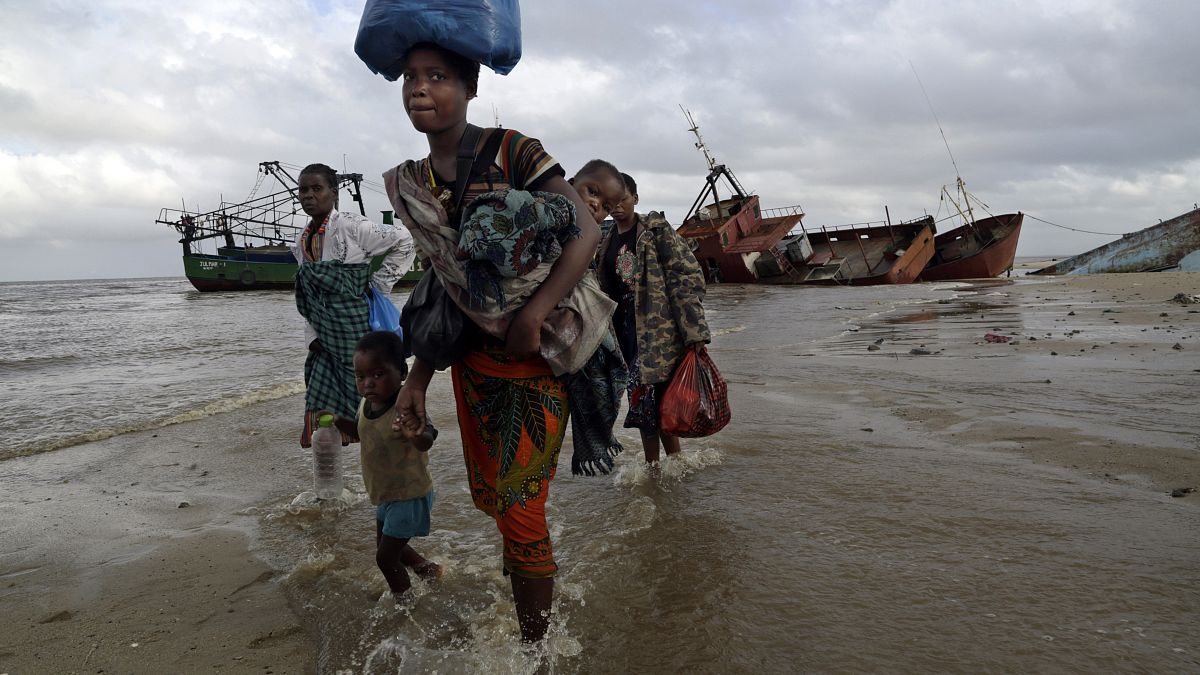 famiglie sfollate arrivano dopo essere state salvate in barca da una zona allagata del distretto di Buzi, 200 chilometri (120 miglia) fuori Beira, Mozambico.