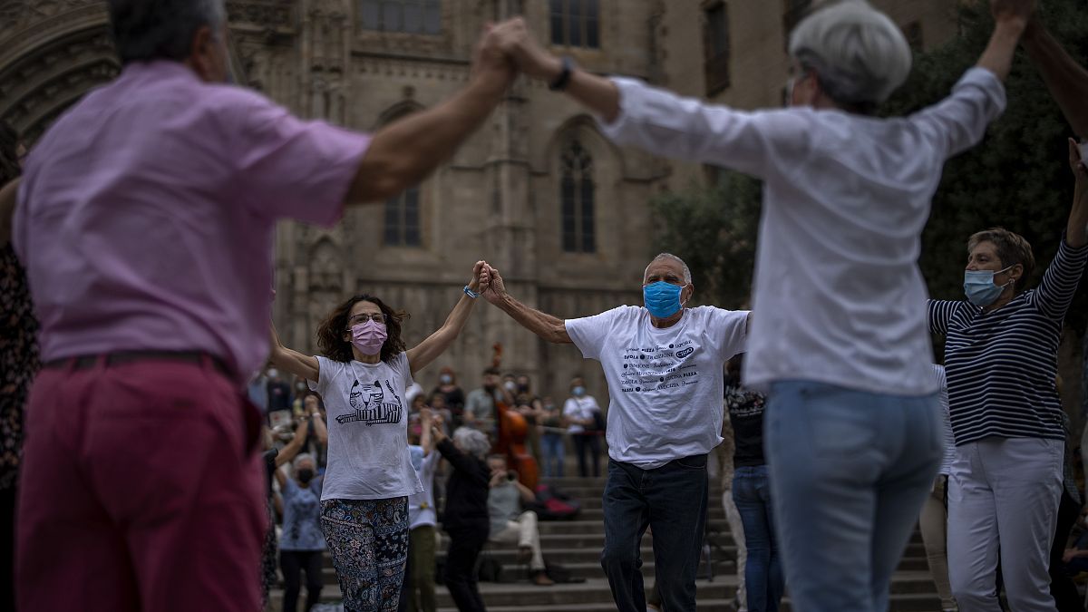 People wearing face masks to protect against COVID-19 perform a traditional Catalan dance in Barcelona, Spain, on June 5, 2021.