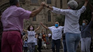 People wearing face masks to protect against COVID-19 perform a traditional Catalan dance in Barcelona, Spain, on June 5, 2021.