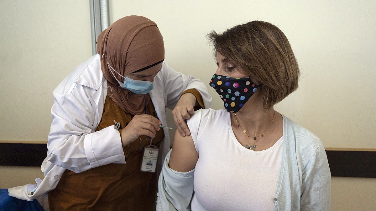 فلسطينية عاملة في القطاع الطبي تتلقى جرعة من لقاح فايزر/بيونتك 