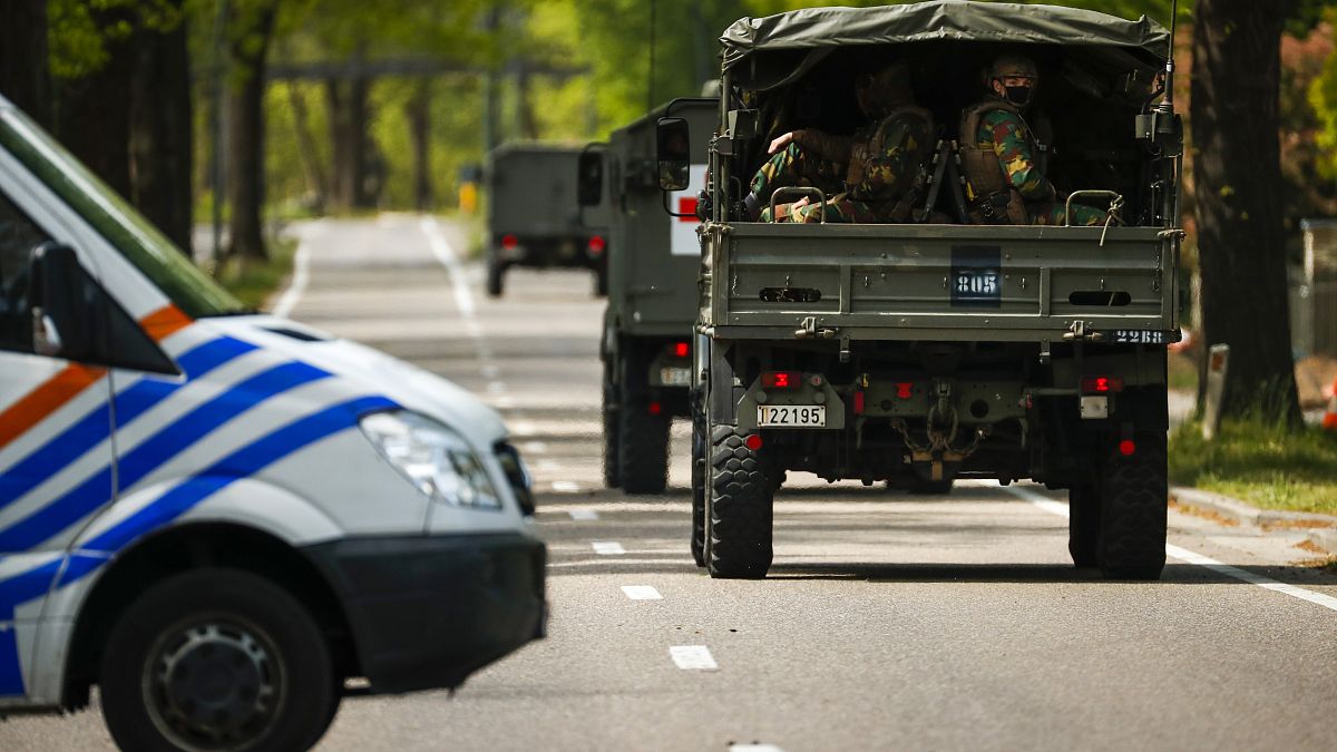 FILE - In this Friday, May 21, 2021 file photo, Belgian military ride in a convoy during a manhunt for an armed soldier in Maasmechelen, Belgium.