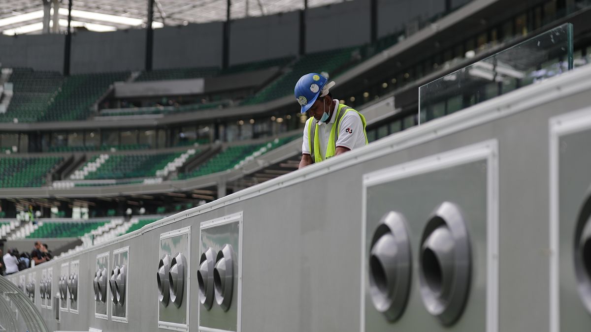 A worker cleans above air conditioning vents at Qatar Education Stadium, one of the 2022 World Cup stadiums, in Doha, Qatar.
