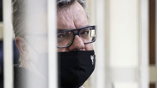 Viktor Babariko sat inside a cage in the Misnk court room as his sentence was read.