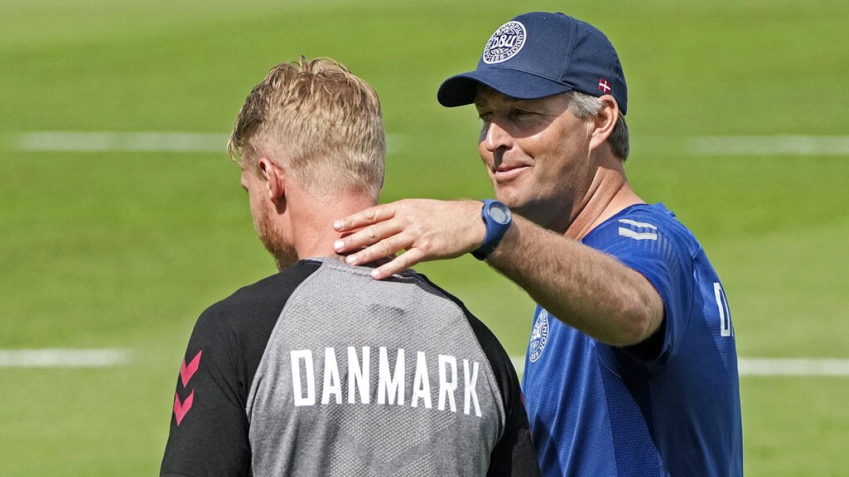 Denmark's captain Simon Kjaer, left, gets touched on the shoulder by Denmark's manager Kasper Hjulmand during a training session at the training ground in Helsingor, Denmark.