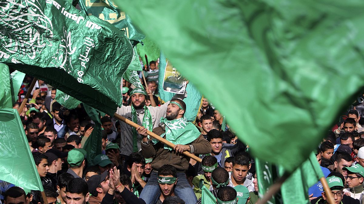 متظاهر فلسطيني يلوح بعلم حركة المقاومة الإسلامية (حماس)  