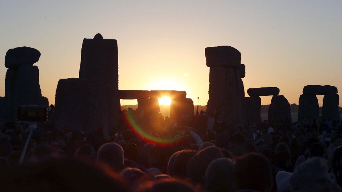 The sun rises over the ancient stone circle in Wiltshire, England on the summer solstice in 2019.