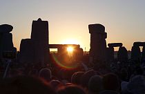The sun rises over the ancient stone circle in Wiltshire, England on the summer solstice in 2019.