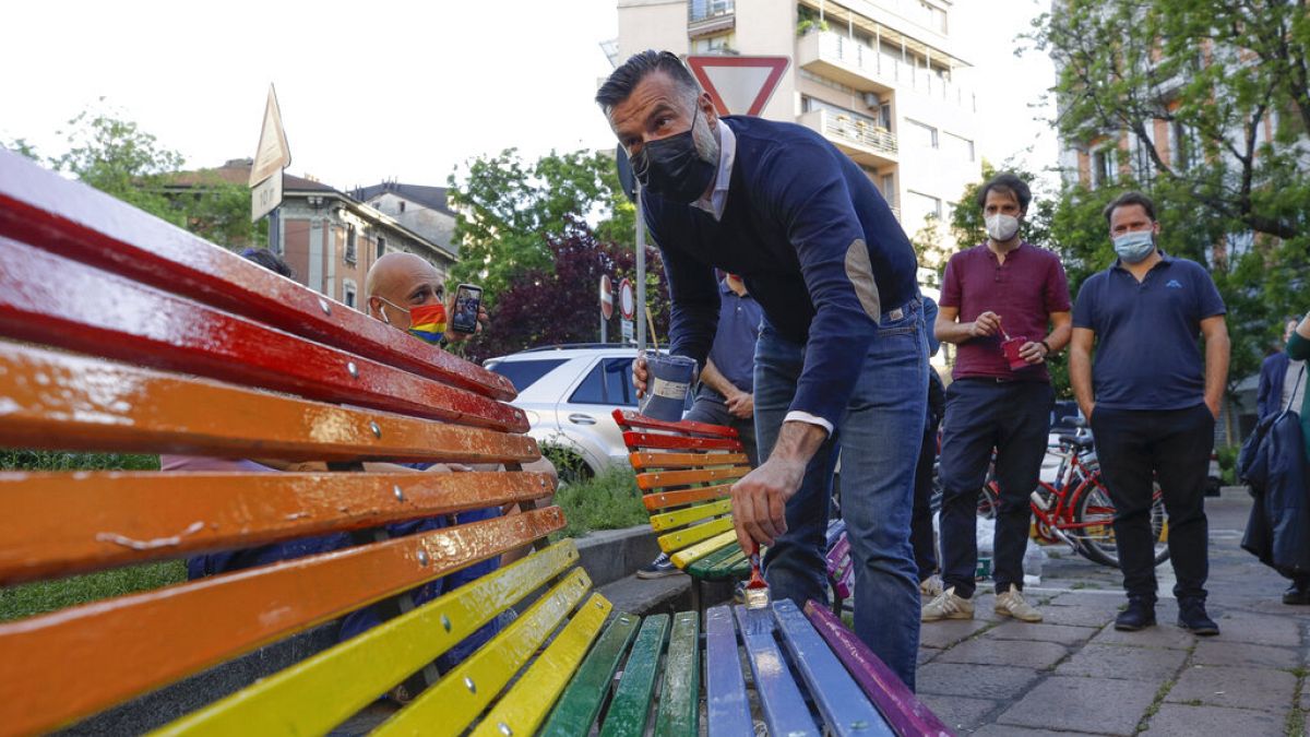FILE - In this Friday, May 7, 2021 filer, Italian lawmaker Alessandro Zan paints a bench in the colors of the rainbow, in Milan, Italy. 