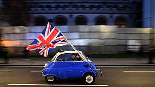 A man waves Union flags as he drives past Brexit supporters gathering in in central London in 2020