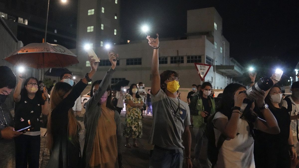 Supporters wave flashlights outside the Apple Daily headquarters in Hong Kong, Wednesday, June 23, 2021.