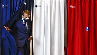 الرئيس الفرنسي إيمانويل ماكرون يغادر صندوق الاقتراع خلال الجولة الأولى من الانتخابات الإقليمية، في لو توكيه-باريس-بلاج، شمال فرنسا، الأحد 20 يونيو 2021.