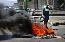 متظاهر يحرق الإطارات خلال احتجاج على ارتفاع أسعار السلع الاستهلاكية وانهيار العملة المحلية، في بيروت، لبنان، الخميس 17 يونيو 2021.