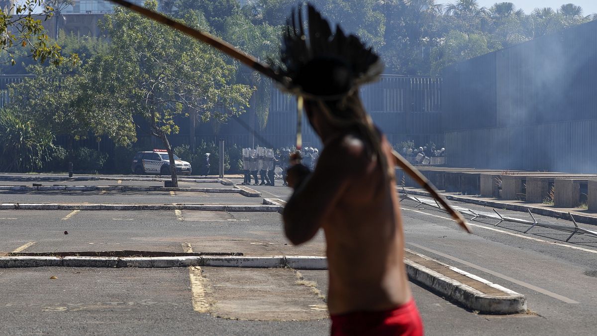 Un indio dispara una flecha contra la fuerzas del orden frente al parlamento de Brasil, en Brasilia.