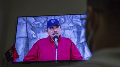 Un hombre sigue el discurso televisado del presidente de Nicaragua, Daniel Ortega, en su casa de Managua