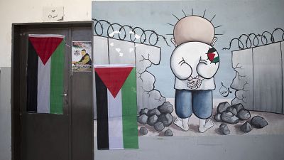 معلقة كاريكاتور للطفل الفلسطيني محمد حمايل توشح باب قسم مدرسي من بلدة بيتا في الضفة الغربية المحتلة. 