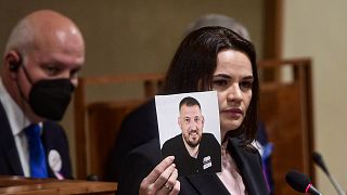 Belarusian opposition leader Sviatlana Tsikhanouskaya, holds a picture of her husband, facing trial in Belarus, while addressing the Czech Senate in Prague, June 9, 2021.