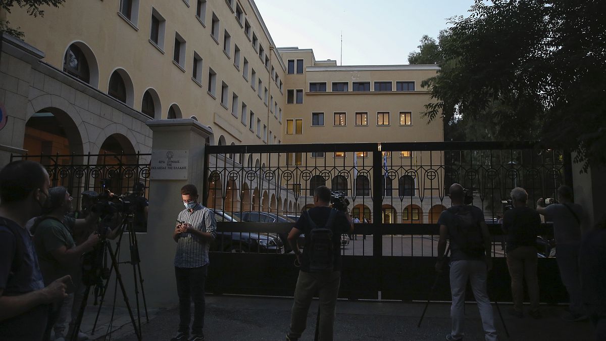 Journalists and cameramen stand outside Petraki Monastery in Athens following an attack.