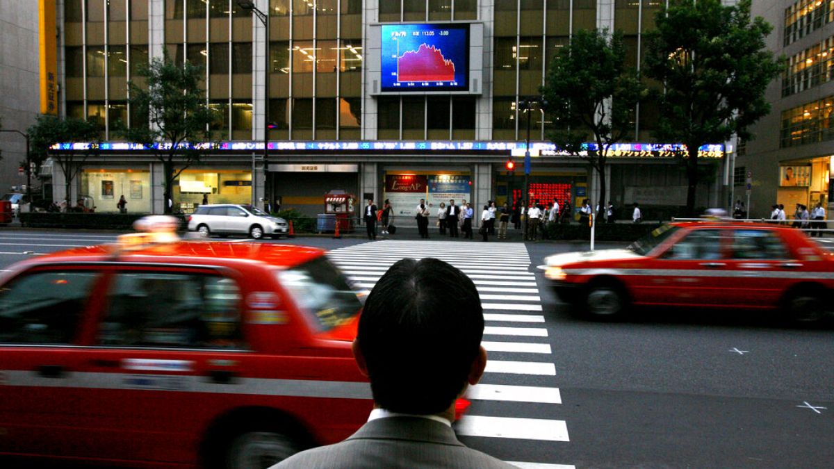 FILE: a Japanese man looks up at an electronic stock price board, in Tokyo, Aug. 17, 2007.