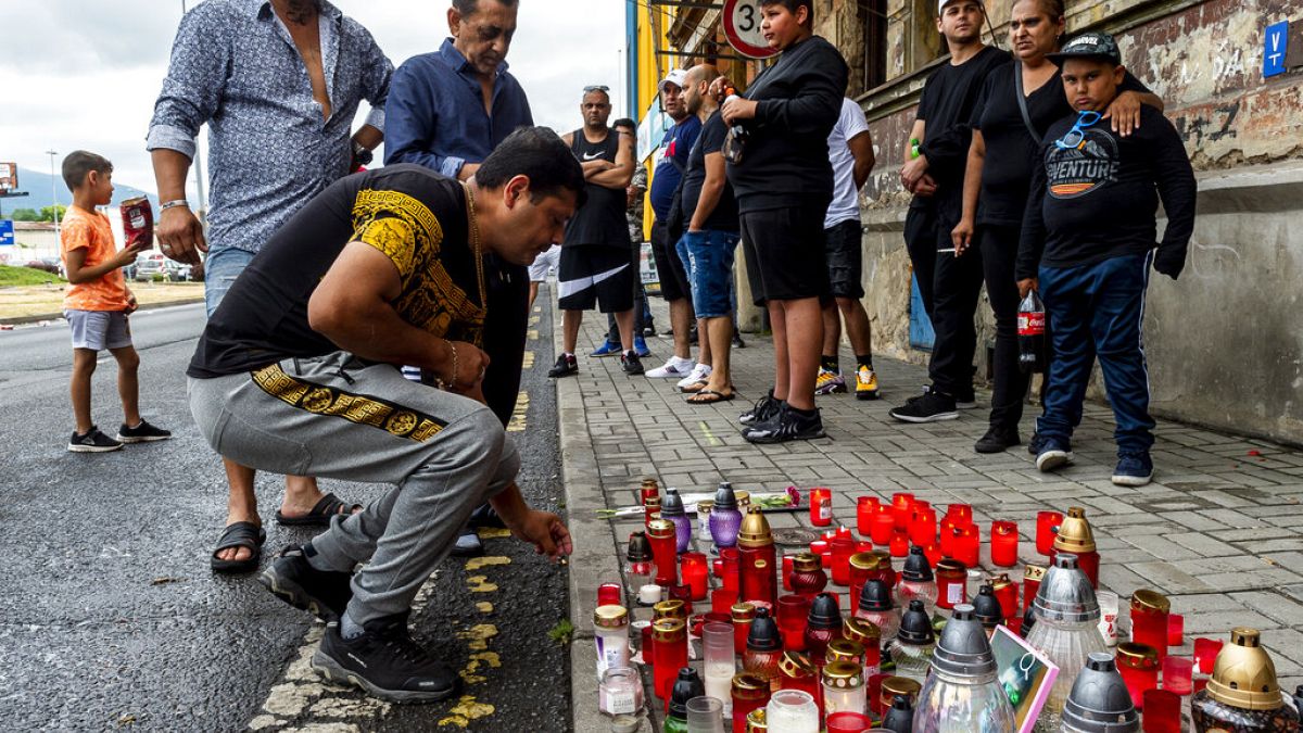 A man  lighting up candle Tuesday, June 22, 2021  in Teplice, Czech Republic, in the place where a Roma man died in an ambulance after a police action on Saturday, June 19. 