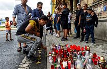 A man  lighting up candle Tuesday, June 22, 2021  in Teplice, Czech Republic, in the place where a Roma man died in an ambulance after a police action on Saturday, June 19.