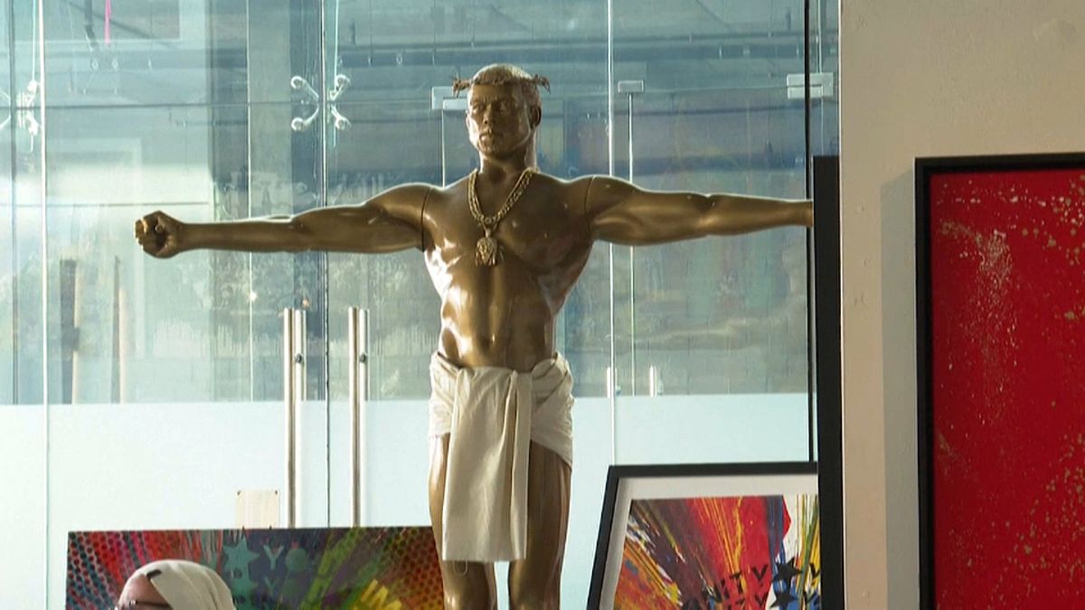 كاني ويست في صورة تمثال ذهبي للمسيح معروض للبيع في معرض فني