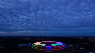 An overview picture shows the Olympic stadium illuminated with the Rainbow colours, in Berlin