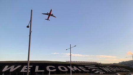 A giant sign painted near the main runway of the Wellington International Airport greets travellers returning home on April 19, 2021.