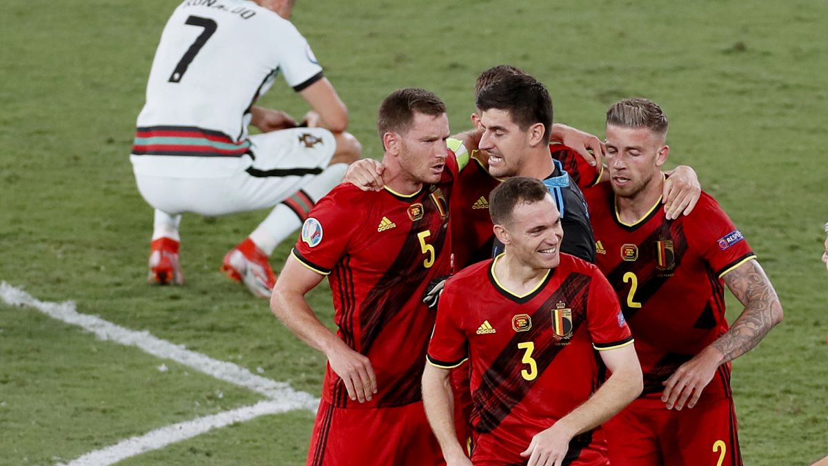 Belgium players celebrate winning 1-0 as Portugal's Cristiano Ronaldo, 7, reacts after their Euro 2020 round of 16 match at La Cartuja stadium in Seville, Spain, June 27, 2021