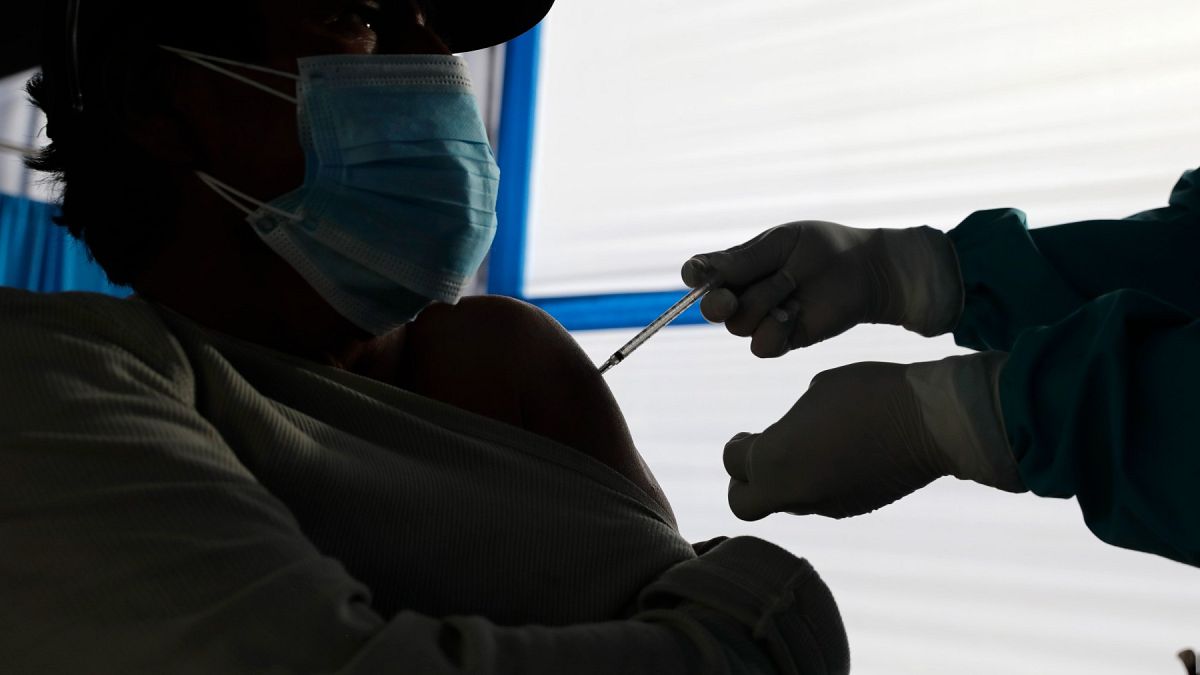 Un trabajador sanitario inocula a un hombre una dosis de la vacuna COVID-19 de Pfizer, en Arequipa, Perú, el sábado 26 de junio de 2021.