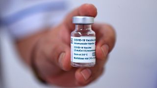 A doctor holds up a vial of AstraZeneca COVID-19 vaccine before giving the inoculation in Hanoi, Vietnam on June 27, 2021.