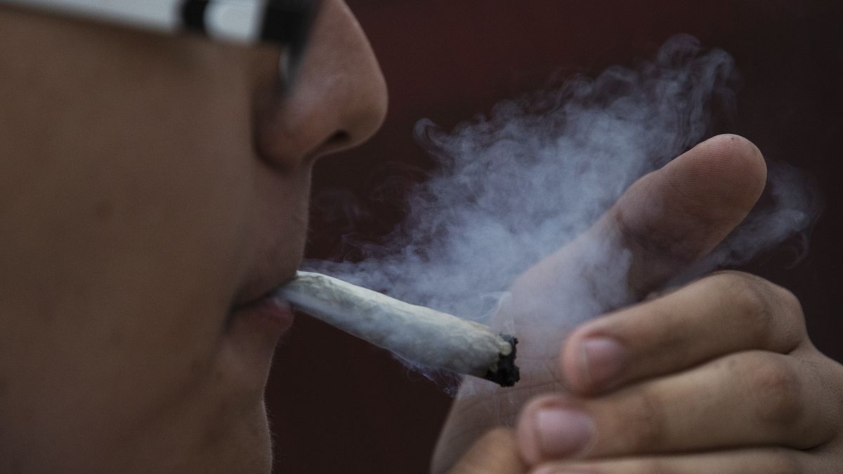 شاب يدخن الماريجوانا أمام مبنى مجلس الشيوخ المكسيكي في مكسيكو سيتي.