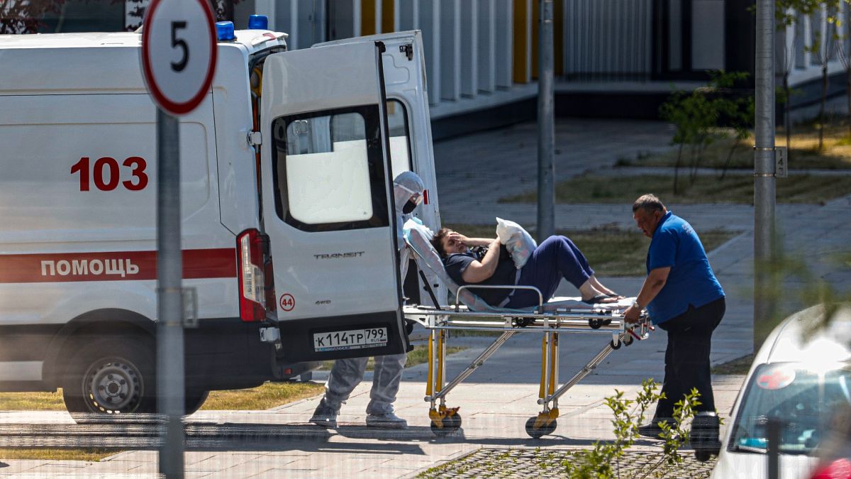 Medical workers carry a patient suspected of having coronavirus on a stretcher at a hospital in Kommunarka, outside Moscow, Russia, June 26, 2021. 