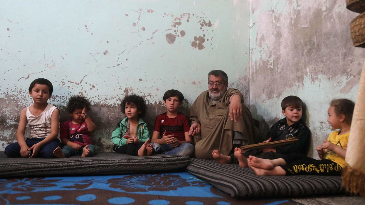 النازح السوري مصطفى شعبان أبو خليل يجلس بين أطفاله في منزلهم في مدينة الباب شمال غرب حلب، شمال سوريا، 23 يونيو 2021