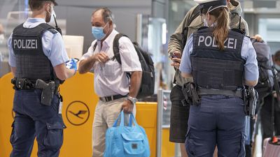 Federal police officers check passengers arriving aboard a flight from Portugal, at Frankfurt airport, Germany, Tuesday June 29, 2021. 