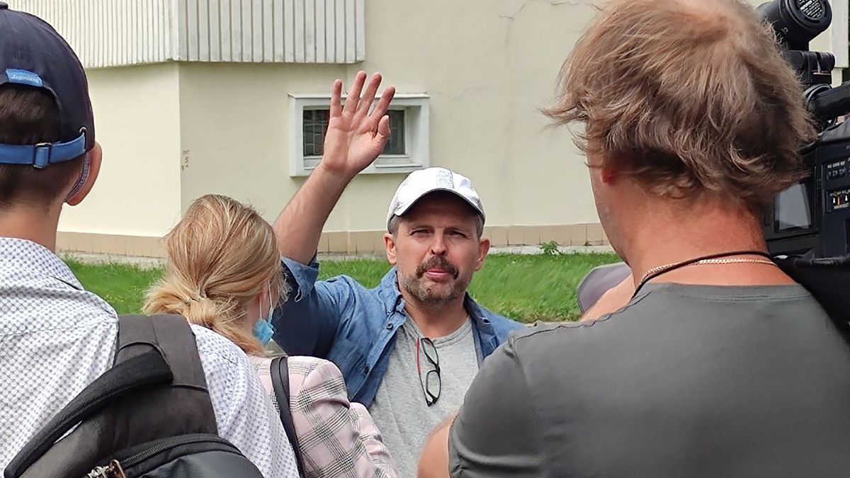 Roman Badanin, chief editor of the Proekt investigative online outlet, waves journalists as he departing to police station in Moscow, Russia, Tuesday, June 29, 2021. 