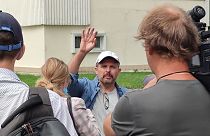 Roman Badanin, chief editor of the Proekt investigative online outlet, waves journalists as he departing to police station in Moscow, Russia, Tuesday, June 29, 2021.
