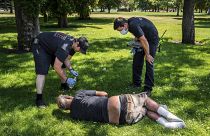 With the temperature well over 100 degrees, officials from a special fire unit check on the welfare of a man in Mission Park in Spokane, Wash., Tuesday, June 29, 2021.