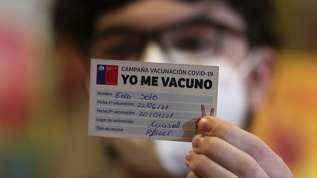 Un joven sujeta un carnet de la campaña Yo Me Vacuno