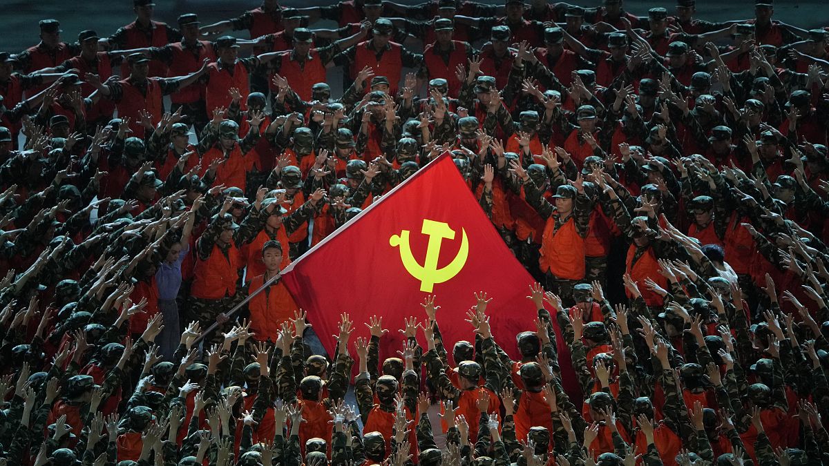 Performers gather around a Communist Party flag during a gala ahead of the 100th anniversary of the founding of the Chinese Communist Party in Beijing on June 28, 2021.