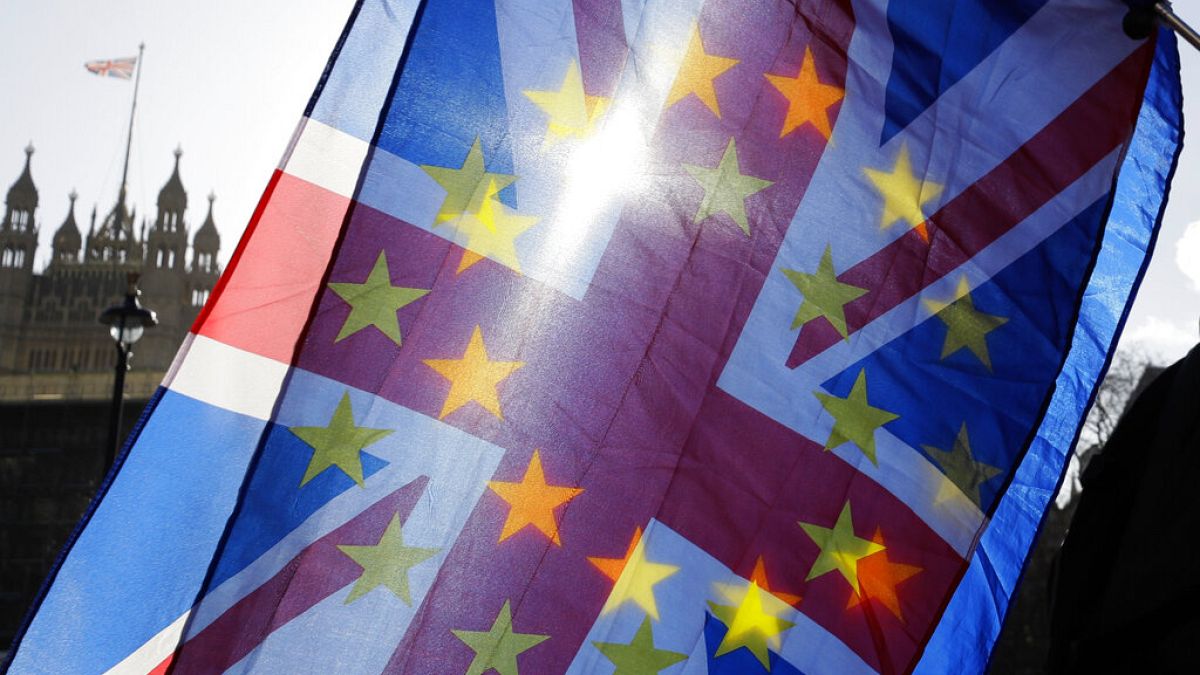 Az EU és az Egyesült Királyság zászlói, háttérben a brit parlament