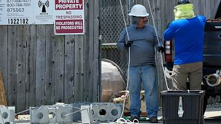 Workers in hot weather work at a Radio Frequency Environment area in Riverwoods, Ill., Monday, June 17, 2024.