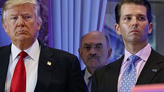 This file photo from Jan. 11, 2017, shows President-elect Donald Trump, left, his chief financial officer Allen Weisselberg, center, and his son Donald Trump Jr.