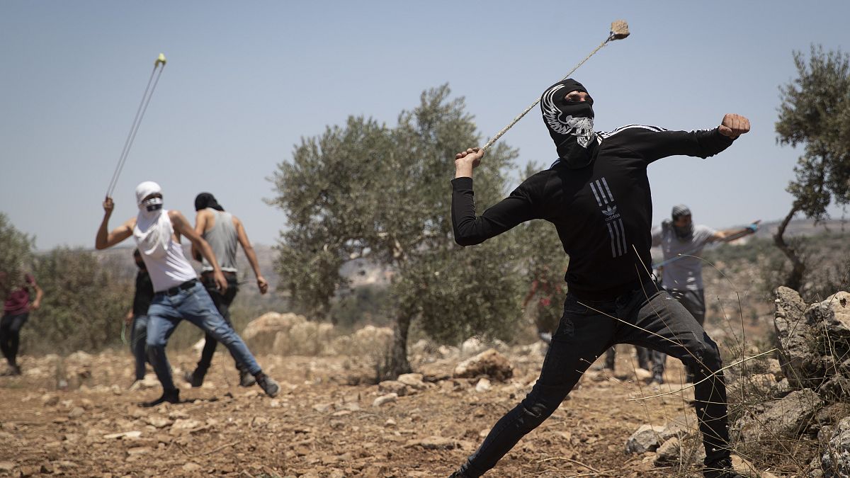 فلسطينيون يستخدمون المقلاع لرشق الحجارة خلال احتجاج على البؤرة الاستيطانية التي أقيمت في قرية بيتا الفلسطينية. 