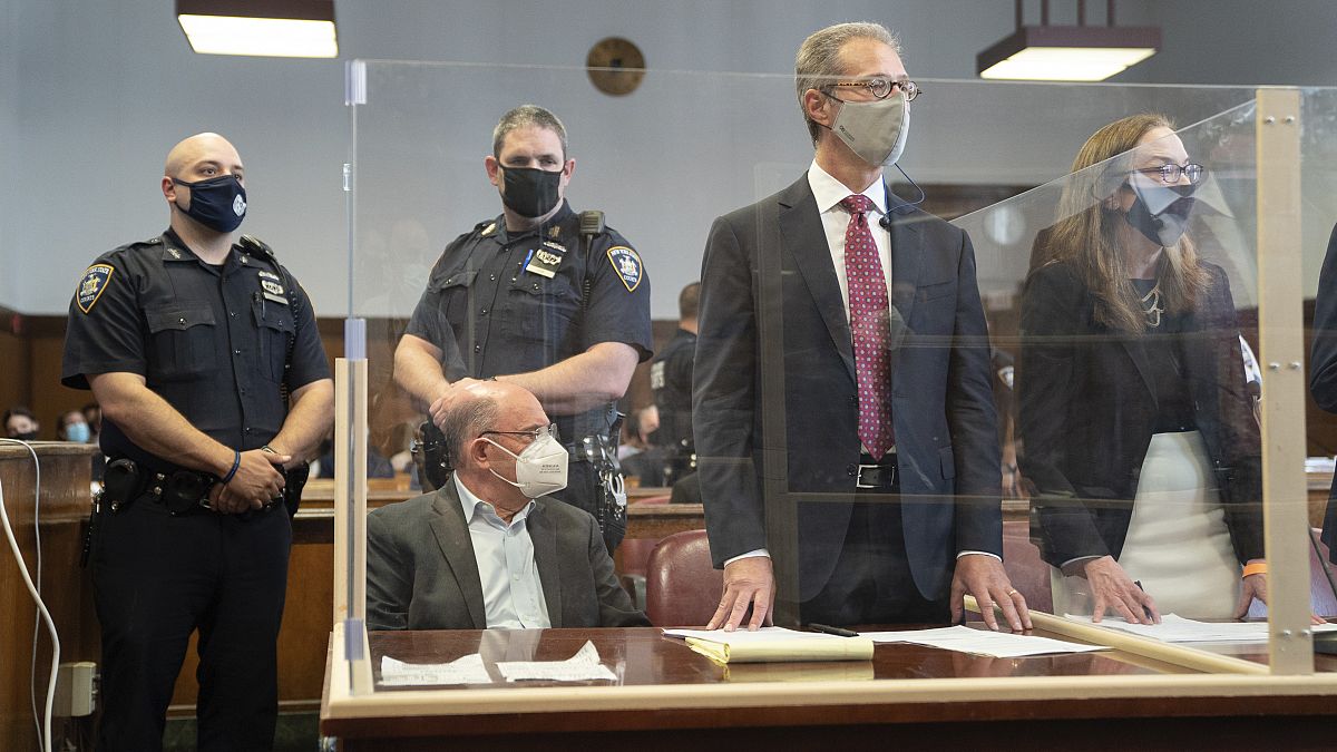 المديرُ المالي لمنظمة ترامب، ألان وايسلبرغ، جالسٌ في المحكمة وخلفه ضابطا شرطة