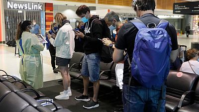 Passengers arriving from Melbourne are screened by health workers at the airport in Sydney, Australia, Friday, Feb. 12, 2021. Passengers arriving from Melbourne are screened by health workers at the airport in Sydney, Australia, Friday, Feb. 12, 2021.