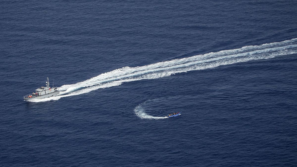 An overcrowded migrant boat, bottom, tries to escape from the Libyan Coast Guard in the Mediterranean, June 30, 2021. Sea-Watch is denouncing both Libya and the EU.